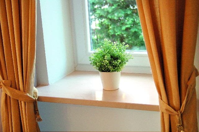 Marmurowy parapet o prostej formie zamontowany we wnęce okiennej