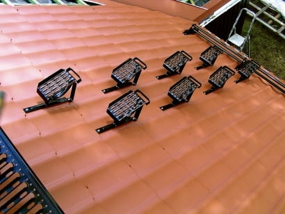 Stopnie kominiarskie umieszczone gęsto na dachu. Zapewniają bezpieczne dojście od okapu do widocznej w lewym rogu zdjęcia ławy kominiarskiej.