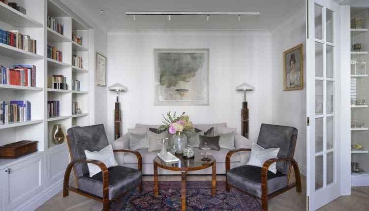 DESIGNERSKIE fotele Thoneta, autentyczne lampy stojące i stolik z lat 20 ubiegłego wieku. oraz zabytkowy dywan zostały wyszukane przez gospodarzy i przyjaciółkę pani domu – Annę Bimer na Warszawskich Targach Antyków w Broniszach. Kolorystykę odnowionej tapicerki foteli, współczesnej kanapy, a nawet zdobiących ją poduszek (ze sklepu sweetliving.pl oraz marki Maja Laptos) dopasowano do palety barw głównego obrazu, zdobiącego ścianę nad sofą. To grafika wspomnianej artystki Anny Bimer.