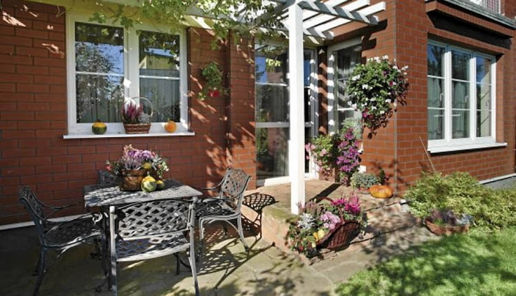 Aranżacje ogrodów. Mały ogród w kwiatach. Na ścianach, stoliku, schodkach - miejsce dla kwiatów znajdzie się wszędzie