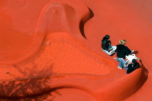 Stadtlounge St.Gallen, Schweiz. Gestalter: die Multimediakünstlerin Pipilotti Rist und der Architekt Carlos Martinez. Ein leuchtend roter Teppich bedeckt Boden, Bänke, Tische und Brunnen. Das erste öffentliche Wohnzimmer der Schweiz ist ein einzigartiges Kunstprojekt im öffentlichen Raum: Wo früher Stoffe der St. Galler Textilindustrie zum Bleichen ausgebreitet wurden, ist das moderne Bankenzentrum Raiffeisen entstanden. | City Lounge St.Gallen, Switzerland, designer: artist Pipilotti Rist and architect Carlos Martinez.