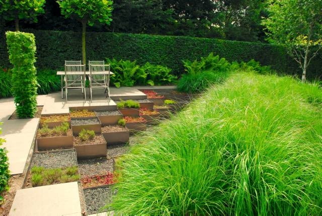 Sprytne rozwiązanie - ogród z 'samoobsługowych' sukulentów w aluminiowych skrzyniach i gigantyczej rabaty z trwałych ozdobnych traw.