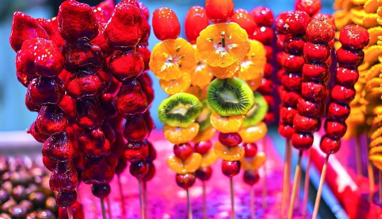 W Azji karmelizowane owoce są bardzo popularne. Sprzedaje się je na patyczkach niczym u nas lizaki. Natomiast w Stanach Zjednoczonych na Halloween popularne są 'candy apples'.