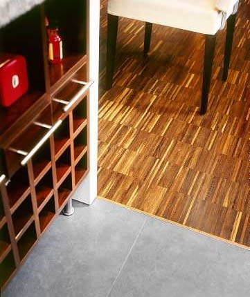 Między parkietem a płytkami ceramicznymi ułożono tzw. listwę dylatacyjną. Zakrywa ona szczelinę - niezbędną w tym miejscu, by drewno mogło 'pracować'. Projekt wnętrza: Radosław Guzowski