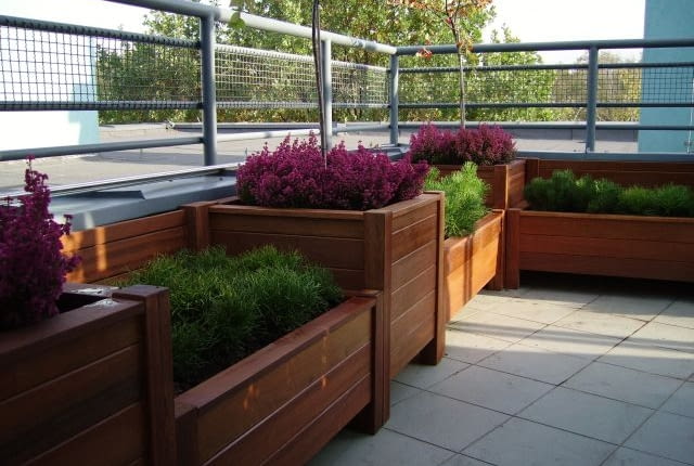 Drewniane skrzynie z roślinami. Można w nich sadzić rośliny na stałe oraz wstawiać mniejsze doniczki - wymieniane w zależności od sezonu