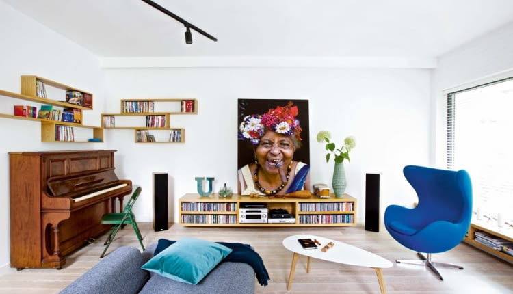 Wyraziste, wielkoformatowe zdjęcie stało się dominującym elementem aranżacji. W takim przypadku, dobierając wyposażenie, dobrze jest wprowadzić akcenty nawiązujące kolorystycznie do eksponowanej fotografii. W tym wnętrzu kolor fotela stanowi echo chabrowej chusty sportretowanej Kubanki.