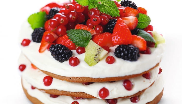 Torcik owocowo-śmietanowy ozdobiony listkami mięty.