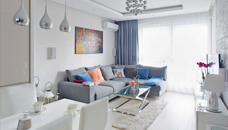 Pokój dzienny połączony z kuchnią to serce domu. Na narożnej kanapie (z firmy Rafek) zmieszczą się nie tylko domownicy, ale i goście. We wnętrzu Julita połączyła nowoczesność z elementami glamour. Meble i dodatki o błyszczących powierzchniach odbijają światło, dodatkowo rozjaśniając pomieszczenie dobrze oświetlone lampami (marki Azzardo).