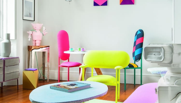 Na stuprocentowo papierowym dywanie Paper Carpet (proj. Scholten & Baijings) błękitny stolik ze spienionego poliuretanu z kolekcji Cotton Candy holenderskiej pracowni Handmade Industrials. W rogu niski złoty taboret autorstwa Karen Chekerdjian.