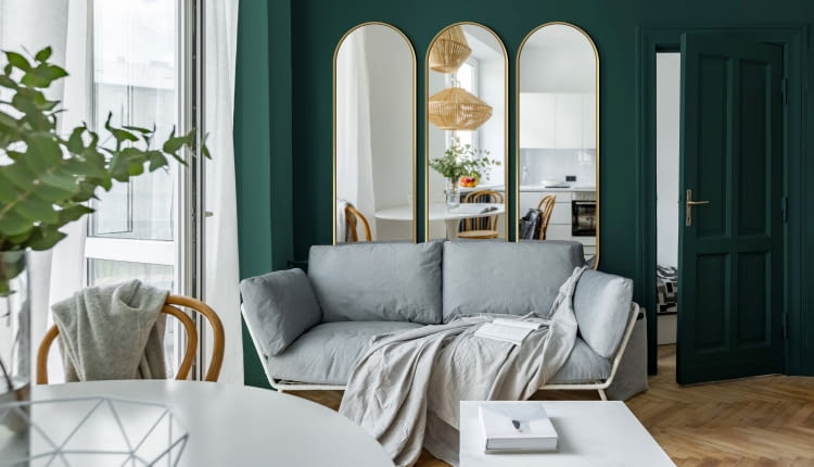 Optyczne powiększenie można uzyskać, wieszając obok siebie kilka luster. Tutaj trzy modele Ambient, w delikatnej złotej ramie.