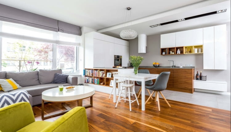 PÓŁWYSEP KUCHENNY od strony pokoju zmienia się w biblioteczkę. Nad stołem (IKEA) wisi oryginalna lampa Caboche (proj. Patricia Urquiola i Eliana Gerotto). Jest zbudowana z poliuretanowych kul, które zwielokrotniają światło.