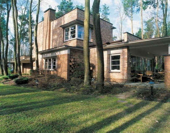 Widok na dom od strony ogrodu. Architekci dołożyli starań, by podkreślić urodę leśnego otoczenia budynku. Kształty elewacji i formę domu 'wpisano' pomiędzy rosnące wokół sosny i dęby.
