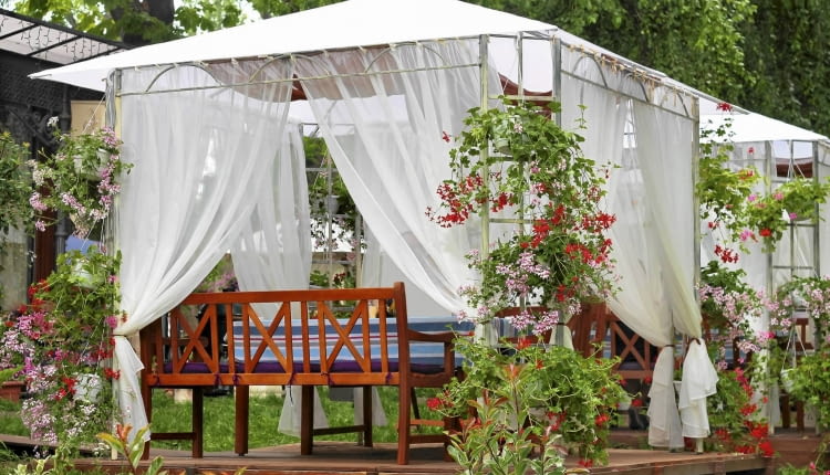 Zadaszony ogrodowy pawilon wsparty na metalowej konstrukcji daje cień ogrodowym biesiadnikom