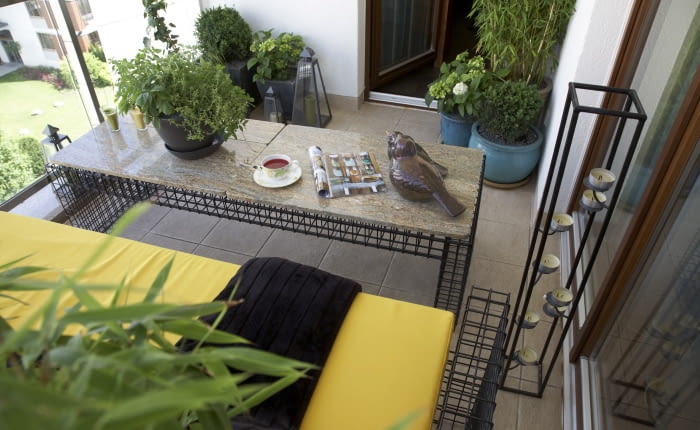 Mały balkon - widok ogólny. Meble balkonowe, bambusy na balkonie