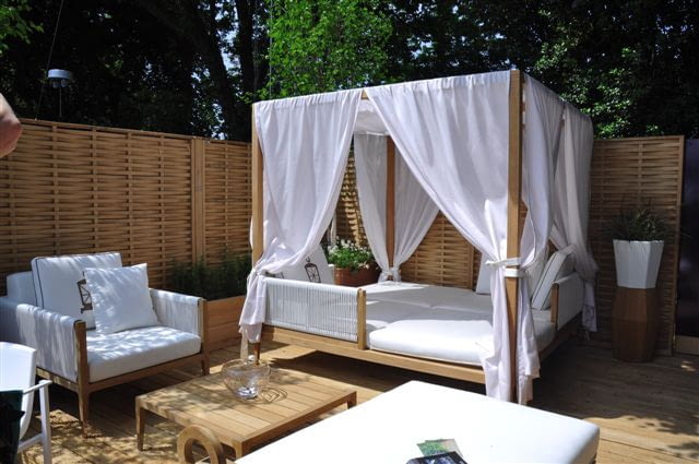 Komfortowe ogrodowe łoże - tkanina rozpięta na drewnianym stelażu chroni nie tylko przed wiatrem, ale też przed komarami.