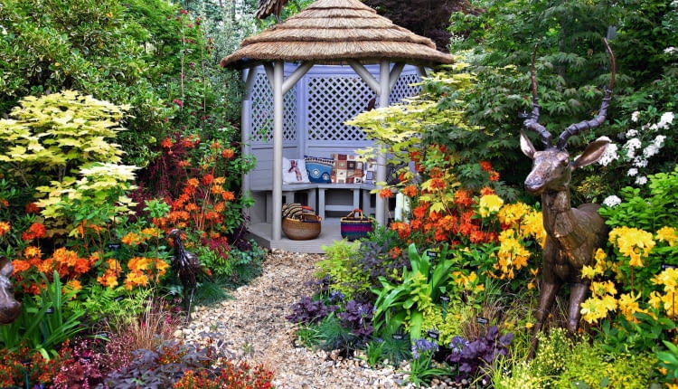 Zagubiona w gąszczu kwiatów altana jest sercem tego romantycznego zakątka. Można do niej dojść ścieżką wysypaną jasnym żwirem.