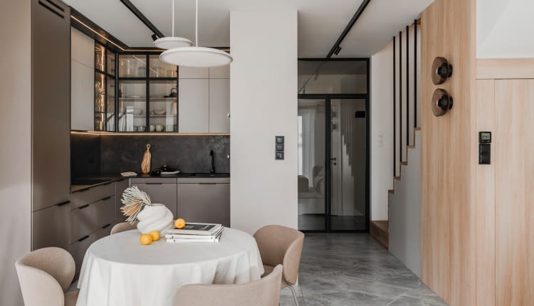 Kuchnia połączona z częścią  dzienną daje wrażenie większej przestrzeni. „Wciągnięta” kolorystycznie do aranżacji salonu współtworzy spójny, uporządkowany wystrój całości.