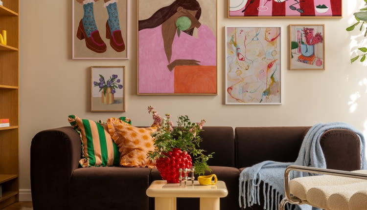 Wieloelementowa kolekcja obrazów w tej aranżacji tworzy spójną całość dzięki zbliżonej kolorystyce i klimatowi vintage. Zarówno na płótnach, jak i w całym salonie wyczuwalna jest swobodna, radosna energia.