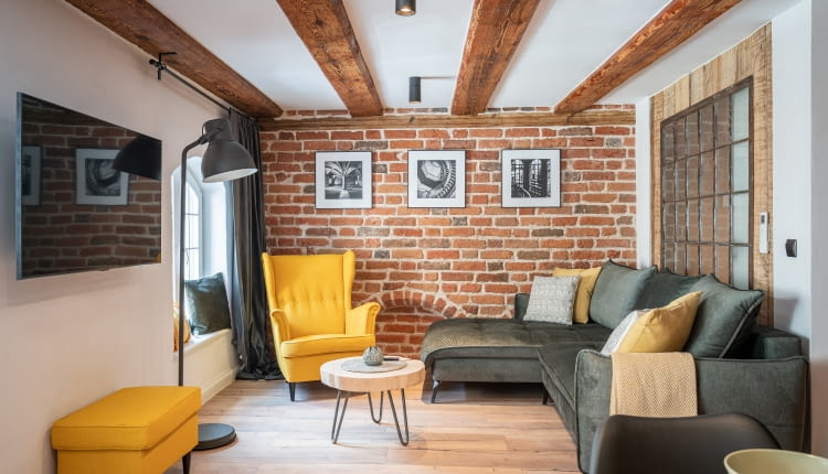 Bardzo efektownym pomysłem jest udekorowanie cegłą ściany w strefie wypoczynku, szczególnie jeśli dopełnia ona rustykalny lub loftowy styl wnętrza.