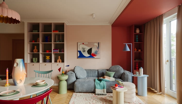 W tym mieszkaniu kolor nie jest dodatkiem, lecz pełnoprawnym bohaterem, który kreuje przestrzeń pełną emocji. Na zdjęciu niebieska sofa to model marki Optisofa, a stojąca niebieska lampa producenta Aldex. Na niebieskim stoliku ze sklepu Jotex wyeksponowano wazon Nana Malwiny Konopackiej. Honorowe miejsce nad sofą zajmuje obraz Agnieszki Pietrzykowskiej.