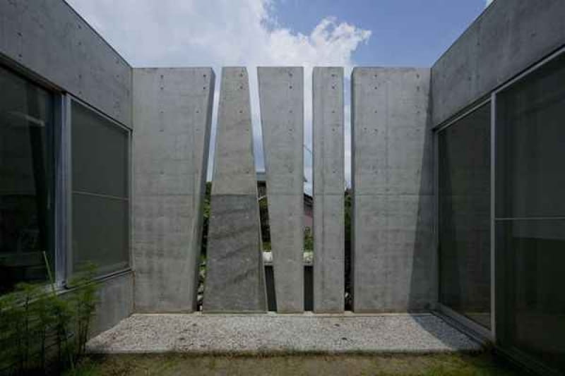 Slit House, czyli Dom Szczelina od EASTERN design office. Budynek otacza betonowy mur długości 105 metrów, w którym zamiast okien wyżłobiono 60 szczelin, tworzą one abstrakcyjny ornament ornament, japońska architektura, eastern design office, fasada, dom jednorodzinny
