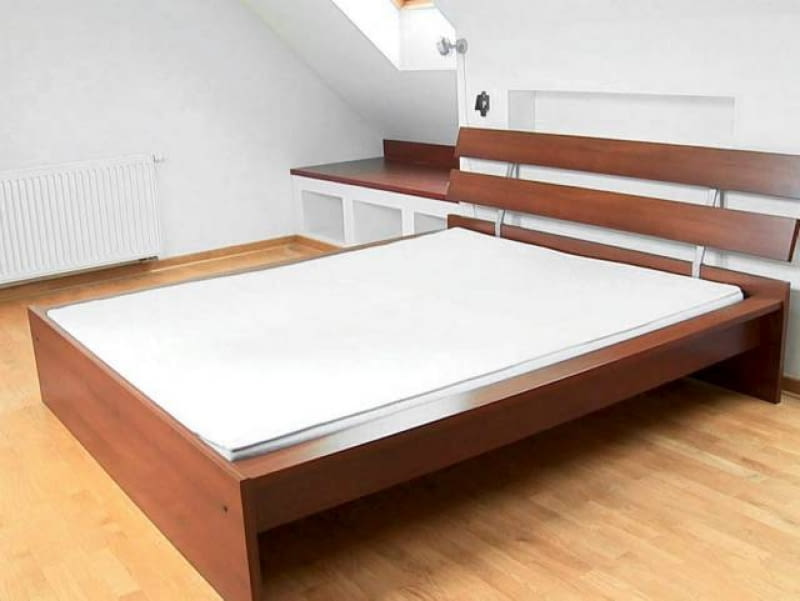 SYPIALNIA PRZED ZMIANĄ. W sypialni brakowało atmosfery sprzyjającej odpoczynkowi. Łóżko o surowej, geometrycznej formie, nadmiar niezagospodarowanych półek w zabudowie pod oknami (również przy wejściu) - choć wnętrze było funkcjonalne, gospodarze poczuli, że nadszedł czas na zmiany. Metamorfoza. Sypialnia. Łóżko. Półki w zabudowie. Wnętrze.