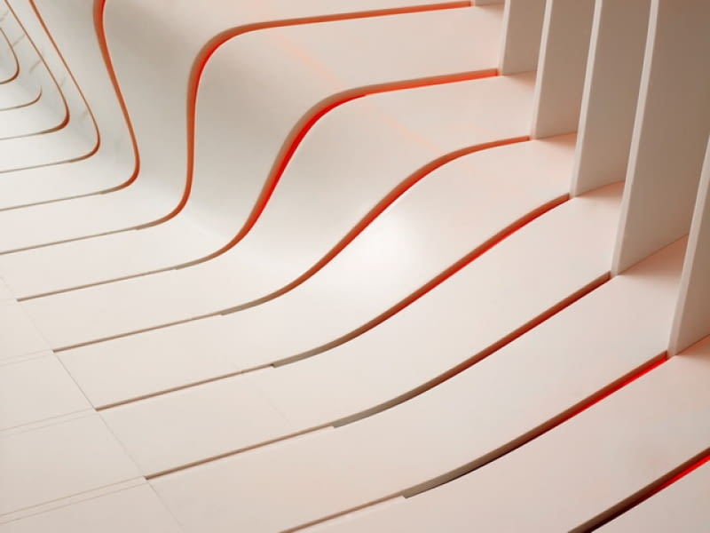 'CORIAN super-surfaces'. Zespół Amanda Levete_Architects wykorzystał materiał DuPont Corian do stworzenia wyjątkowego projektu holu. Statyczne elementy zostały uformowane w taki sposób, aby oddać wrażenie płynnego ruchu. Odpowiednie oświetlenie miało natomiast wydobyć dodatkowo próżnię i podsycić wizualny efekt kinetyczności całej instalacji. corian, dupont, architektura, Amanda Levete Architects