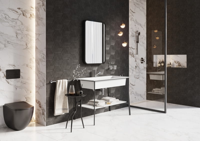 Minimalistyczna czarna konsola doskonale uzupełnia wystrój łazienki, nie odciągając uwagi od ciekawie zdobionych płytek, nowoczesnego lustra czy oryginalnego oświetlenia