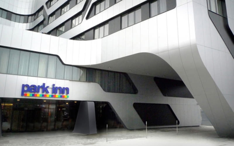Widok na wejście główne hotelu Park Inn. Po prawej przejazd pod skrzydłem hotelowym w formie leja wyżłobionego w bryle budynku. Ovotz design lab., jurgen mayer, hotel, kraków, Park Inn, architektura, projekt, futuryzm, elewacja
