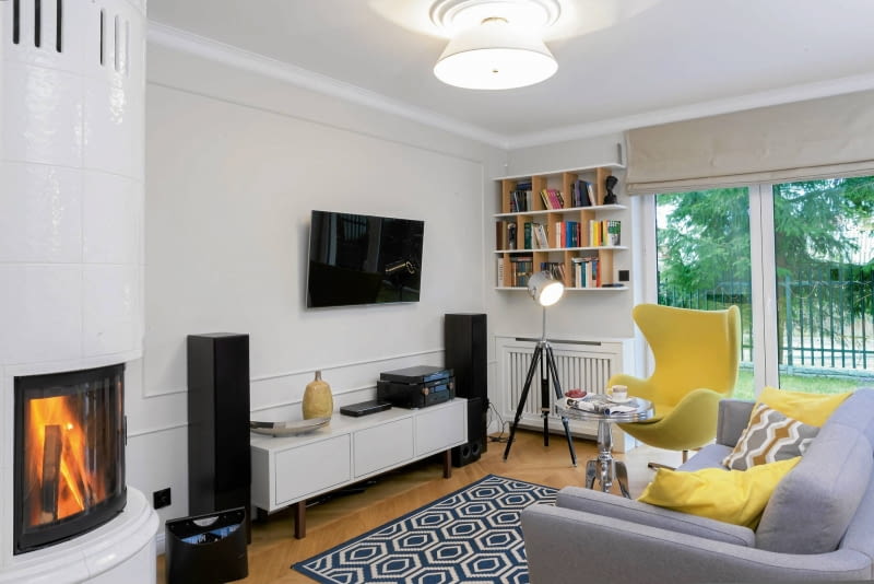 W EKLEKTYCZNYM SALONIE znalazło się miejsce zarówno dla metalowego stolika w stylu glamour, jak i prostej szafki z IKEA czy loftowej lampy stojącej. Nowoczesny grzejnik ukryto za estetyczną ażurową przesłoną. salon, aranżacja salonu