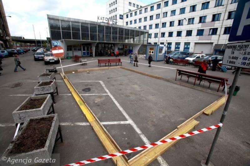 11 maja. Na Placu Oddziałów Młodzieży Powstańczej pojawił się tajemniczy prostokąt. Ekipa remontowa ułożyła go z grubych desek na asfalcie. W tym miejscu według planów kolei mają w przyszłości stanąć kontenery pełniące funkcje kas. Może to wstęp do ich ustawienia? 11.05.2010 , KATOWICE , PRZEBUDOWA DWORCA PKP , MIEJSCE W KTORYM POWSTANA ZASTEPCZE KASY BILETOWE. FOT. DAWID CHALIMONIUK / AGENCJA GAZETA