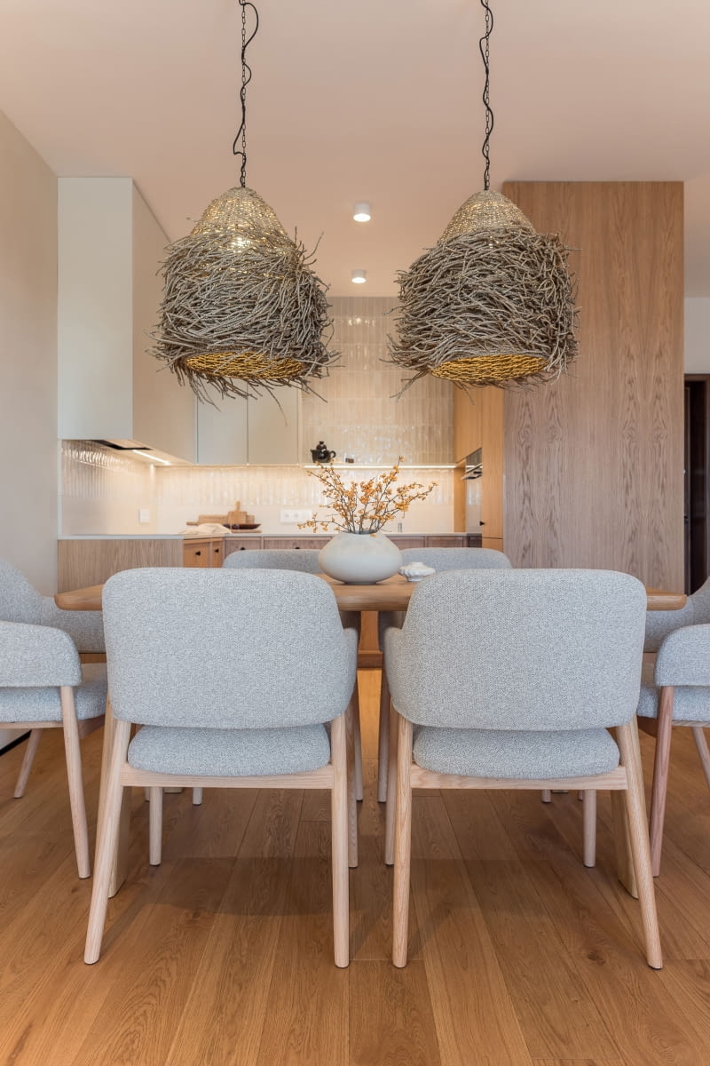 Mocnym akcentem tej przestrzeni są dwie duże, zawieszone nad stołem lampy w stylu boho ze sklepu Atria – plecione niczym ptasie gniazda z naturalnej trawy morskiej.