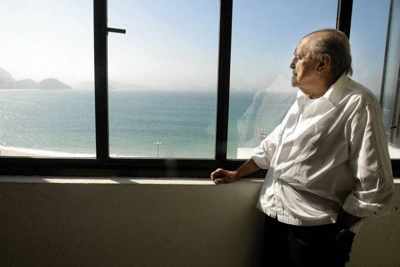 Niemeyer patrzy na Copacabanę z okna swojego biura. Zdjęcie z 2003 roku Brazilian architect Oscar Niemeyer looks at the Copacabana beach from his office after his interview with Reuters in Rio de Janeiro, in this June 16, 2003 file photo. Niemeyer, a towering patriarch of modern architecture who shaped the look of contemporary Brazil and whose inventive, curved designs left their mark on cities worldwide, died late on December 5, 2012. He was 104. Niemeyer had been battling kidney and stomach ailments in a Rio de Janeiro hospital since early November. His death was the result of a lung infection developed this week, the hospital said, little more than a week before he would have turned 105. REUTERS/Sergio Moraes/Files (BRAZIL - Tags: OBITUARY SOCIETY)