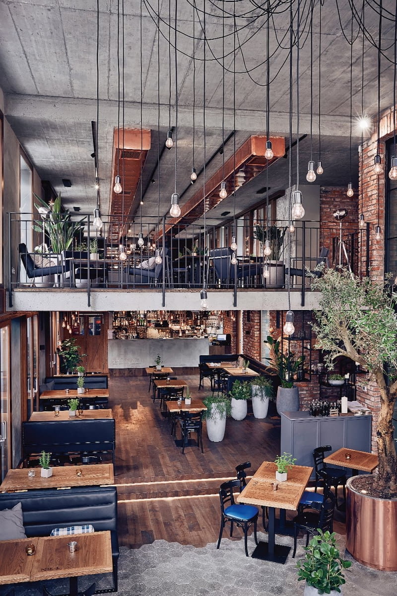 Restauracja ma 300 m2. Projektantki postawiły na proste, szlachetne materiały: cegła, beton, dębowe drewno. Lampy i meble na zamówienie wg projektu Double Look Design. Restauracja Plac Nowy 1, wnętrza, trendy