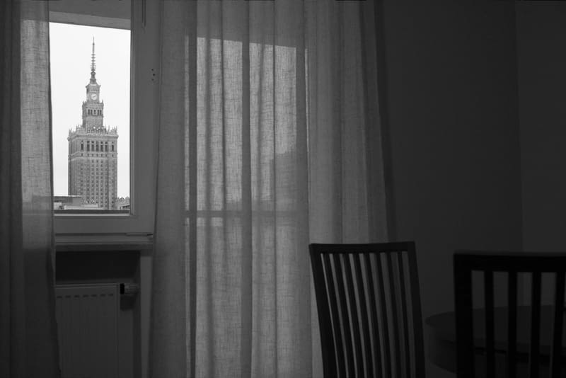 "Pałac Kultury i Nauki - PKiN w oknie stającego niedaleko apartamentowca." "Pałac Kultury i Nauki - PKiN w oknie stającego niedaleko apartamentowca."