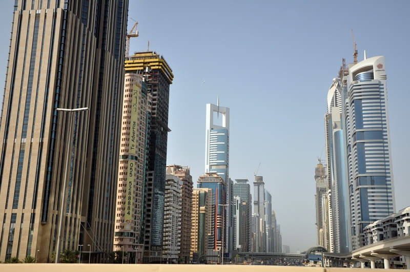 Chyba żadne miasto nie przeżyło takiego boomu inwestycyjnego w ciągu ostatniej dekady, jak Dubaj. Przedstawiamy najciekawsze, choć nie zawsze najlepsze architektonicznie miejsca, które warto zobaczyć będąc w tym przedziwnym mieście - niemieście. Na zdjęciu zabudowa biurowa wzdłuż głównej ulicy Dubaju - Sheikh Zayed Road Dubaj, największe na Świecie, burj dubai, wieżowce, emiraty arabskie, architektura, Sheikh Zayed Road
