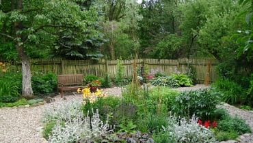 W wilgotnym, lekko zacienionym miejscu rosną funkie, tawułki i języczki. Z ceramicznej beczki pod nieczynną pompą 'wypływają' smagliczki W wilgotnym, lekko zacienionym miejscu rosną funkie, tawułki i języczki. Z ceramicznej beczki pod nieczynną pompą 'wypływają' smagliczki