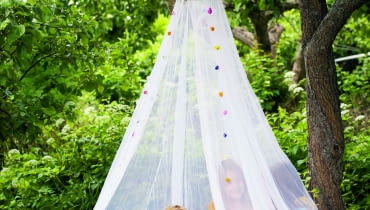 Moskitiera przyda się nie tylko dzieciom. Gdy jest zamknięta, latające owady nie mają do nas dostępu. ACCYBH Girls under a mosquito net.