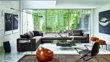 Przy dużej sofie narożnej ustawiono drobne, lekkie meble. Wnętrze urządzone przez włoską markę B&B Italia, www.bebitalia.com