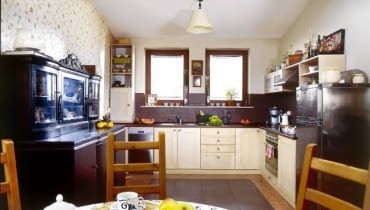 Fronty kuchennych szafek, zrobione z bielonego dębu, kontrastują z głębokim brązem kredensu (nabytek z aukcji internetowej) i gresu nad blatem. Ciemne płytki terakoty na podłodze wyglądają jak dywan. UWAGA PONOWNA PUBLIKACJA ZA ZGODA WLASCICIELI