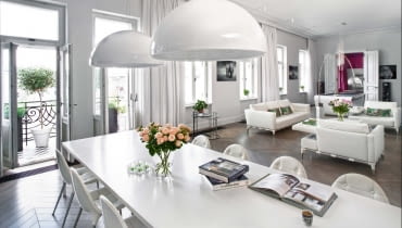 Sofa i fotele Prive (Cassina) zaprojektowane przez Philippe'a Starcka; stoliki kawowe Raymond (Minotti), lampa stojąca Arco (Flos) projektu braci Castiglioni. Pod oknem stolik Adjustable Table E1027 (ClassiCon) projektu Eileen Gray. Z prawej w głębi - kino domowe.