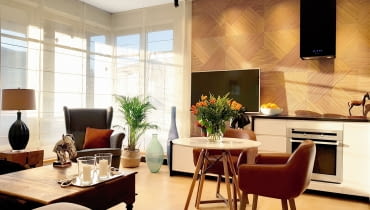Z dawnego salonu otwartego na kuchnię trzeba było utworzyć salon, sypialnię i nową kuchnię. Architekt w miejscu starej kuchni zaprojektował wymarzoną sypialnię Igi, a kuchnię zaplanował w pozostałej części pomieszczania. Nowe szafki kuchenne płynnie przechodzą w niską szafkę, nad którą umieszczono telewizor. Powstał aneks kuchenny z małym stolikiem do jedzenia posiłków, a obok stanęła wygodna kanapa ze stolikiem kawowym. Aranżacja małego salonu z aneksem kuchennym