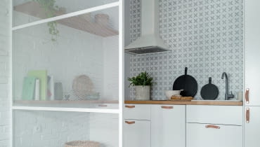 Biała kuchnia kupiona w Ikei służy jako neutralne tło dla drewnianych, wiklinowych i skórzanych elementów. Bazującą na naturalnych materiałach aranżację wzbogaca ściana wykończona cegłą malowaną na biały kolor oraz oryginalna ścianka działowa, wykonana ze stalowej siatki, również malowanej na biało. Cegła i stal to wyraźne odniesienia do architektury fabryki, która stała kiedyś w miejscu praskiego osiedla Bohema. Ich faktura i rysunek ożywiają jasne wnętrze. Biała kuchnia kupiona w Ikei służy jako neutralne tło dla drewnianych, wiklinowych i skórzanych elementów. Bazującą na naturalnych materiałach aranżację wzbogaca ściana wykończona cegłą malowaną na biały kolor oraz oryginalna ścianka działowa, wykonana ze stalowej siatki, również malowanej na biało. Cegła i stal to wyraźne odniesienia do architektury fabryki, która stała kiedyś w miejscu praskiego osiedla Bohema. Ich faktura i rysunek ożywiają jasne wnętrze.