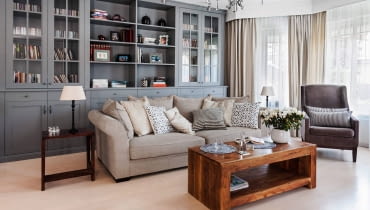 W salonie jedną ze ścian w całości zajmuje polakierowany na szaro drewniany kredens. Zaprojektowała go specjalnie do tego wnętrza architektka Aleksandra Prokopiuk, a wykonał stolarz artysta Jacek Borkowski. W ELEGANCKIM SALONIE jedną ze ścian w całości zajmuje polakierowany na szaro drewniany kredens. Zaprojektowała go specjalnie do tego wnętrza architektka Aleksandra Prokopiuk, a wykonał stolarz artysta Jacek Borkowski. fot. Igor Dziedzicki