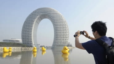 Na zdjęciu hotel i pływające po jeziorze wielkie gumowe kaczki autorstwa holenderskiego artysty Florentijna Hofmana, znanego z widowiskowych działań w przestrzeni publicznej. Hotel w chińskim mieście Huzhou