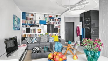 W regale bibliotecznym przewidziano miejsce nie tylko na książki, ale również na barek, głośniki i projektor (ukryty za turkusowymi drzwiczkami, otwieranymi od góry). Rozkładana kanapa to dodatkowe miejsce do spania dla przyjezdnych gości. salon, wystrój wnętrz