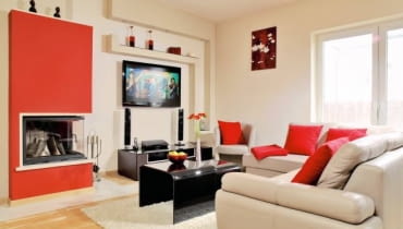 Gospodarze postawili projektantce tylko jeden warunek - w domu ma być dużo czerwieni, bo to ulubiona barwa pani domu. Okazało się, że świetnie pasuje ona do jasnego drewna i kremowych ścian. Od mocnej kolorystyki można odetchnąć tylko w sypialni i jednej z łazienek, gdzie nie ma czerwonych akcentów. <BR /> WNĘTRZA. Czerwień - kolorystyczny motyw przewodni - zestawiono z beżem (ściany, obicie mebli) i czernią urządzeń i hartowanego szkła (stolik kawowy i blat szafki RTV). Warto zwrócić uwagę na podwieszany sufit z czerwonym pasem i na oryginalną obudowę kominka - konstrukcję z płyt gipsowo-kartonowych pomalowano na czerwono. OLYMPUS DIGITAL CAMERA