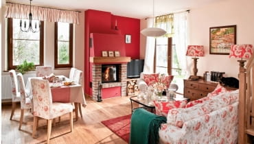 <B>Zgoda: salon, w którym przyjmujemy gości, musi wyglądać reprezentacyjnie. Ale to wcale nie znaczy, że ma być sztywny i oficjalny! Proszę tylko popatrzeć na prezentowane przez nas wnętrza. One dobitnie udowadniają, że elegancja może iść w parze z miłym, domowym klimatem.</B> <BR />MIEJSCE NA RELAKS. Łącząc naturalne materiały z ciepłymi barwami i meblami o ponadczasowych formach, stworzono apetyczny wystrój, który nie znudzi się zbyt szybko. Nutki słodyczy dodały mu tkaniny w kwiatowe wzory. Gdy kiedyś zostaną wymienione, smak tej mieszanki może być już całkiem inny. <BR />Kąt z kominkiem to bardzo ważne miejsce w tym salonie. Jego rangę podkreśla ściana pomalowana na złamany odcień czerwieni, do której konsekwentnie dobrano odcienie wzorów na poduszkach, abażurach lamp oraz pokrowcach przykrywających krzesła i kanapę. Mocne działanie tej barwy tonują duże płaszczyzny kremowej bieli (ściany) oraz jasnego brązu (drewniana podłoga i meble). <B>Zgoda: salon, w którym przyjmujemy gości, musi wyglądać reprezentacyjnie. Ale to wcale nie znaczy, że ma być sztywny i oficjalny! Proszę tylko popatrzeć na prezentowane przez nas wnętrza. One dobitnie udowadniają, że elegancja może iść w parze z miłym, domowym klimatem.</B> <BR />MIEJSCE NA RELAKS. Łącząc naturalne materiały z ciepłymi barwami i meblami o ponadczasowych formach, stworzono apetyczny wystrój, który nie znudzi się zbyt szybko. Nutki słodyczy dodały mu tkaniny w kwiatowe wzory. Gdy kiedyś zostaną wymienione, smak tej mieszanki może być już całkiem inny. <BR />Kąt z kominkiem to bardzo ważne miejsce w tym salonie. Jego rangę podkreśla ściana pomalowana na złamany odcień czerwieni, do której konsekwentnie dobrano odcienie wzorów na poduszkach, abażurach lamp oraz pokrowcach przykrywających krzesła i kanapę. Mocne działanie tej barwy tonują duże płaszczyzny kremowej bieli (ściany) oraz jasnego brązu (drewniana podłoga i meble).