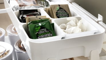 Dodatkowe półki z przegródkami, które można wysuwać na szynach to dobry pomysł na przechowywanie drobnych rzeczy. Jak sprawić, żeby w kuchennych szafkach zmieściło się więcej? Sposoby na organizację