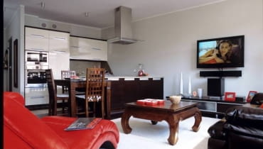 Żeby kolorystyka mieszkania nie była zbyt monotonna, dodano elementy w gorącym odcieniu czerwieni. Taką barwę ma nie tylko wygodny szezlong, ale także dodatki - ramki, naczynia, gazetownik. UWAGA PONOWNA PUBLIKACJA ZA ZGODA WLASCICIELI